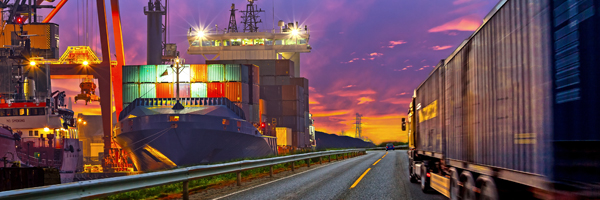 Container shipping company showing container ship at the dockside loading up in the evening